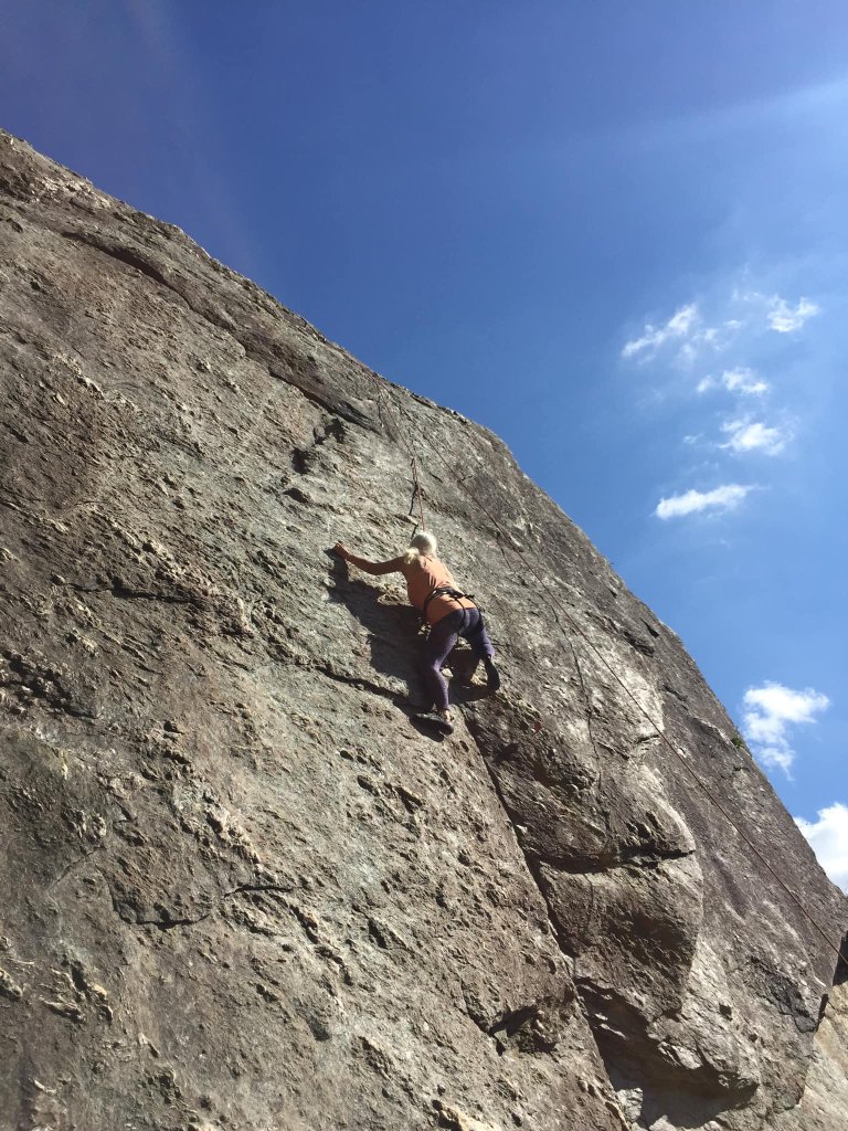 Carol rock climbing on a granite face
